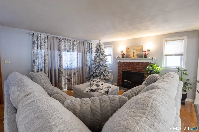 a living room with furniture a fireplace and a window