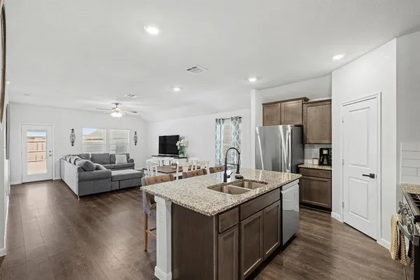 a kitchen with kitchen island a sink and a refrigerator