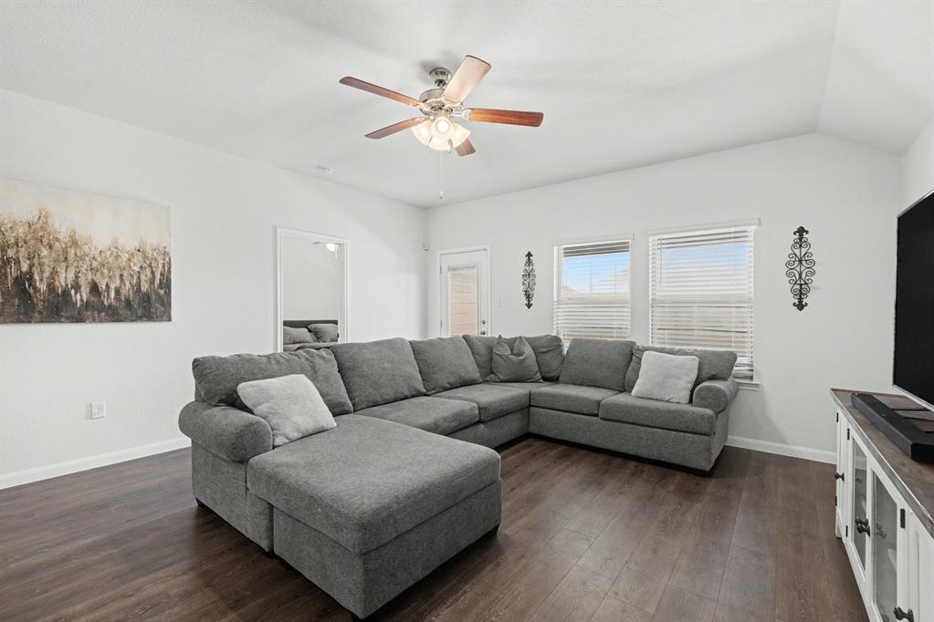 706 Spur Ridge Princeton, TX 75407 - Photo 13 of 36 Living area with dark wood-style floors, ceiling fan, and vaulted ceiling
