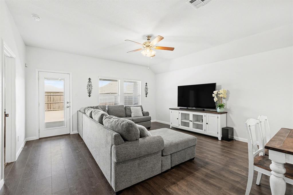 706 Spur Ridge Princeton, TX 75407 - Photo 14 of 36 Living area featuring dark wood finished floors, a ceiling fan, and lofted ceiling