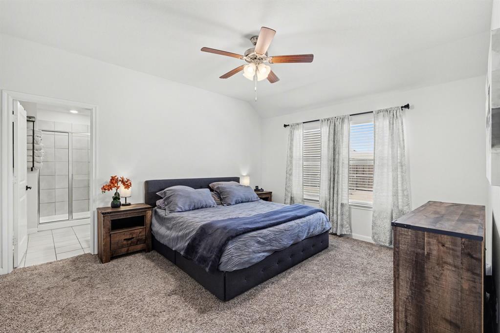 706 Spur Ridge Princeton, TX 75407 - Photo 20 of 36 Bedroom featuring light carpet, a ceiling fan, vaulted ceiling, and ensuite bathroom