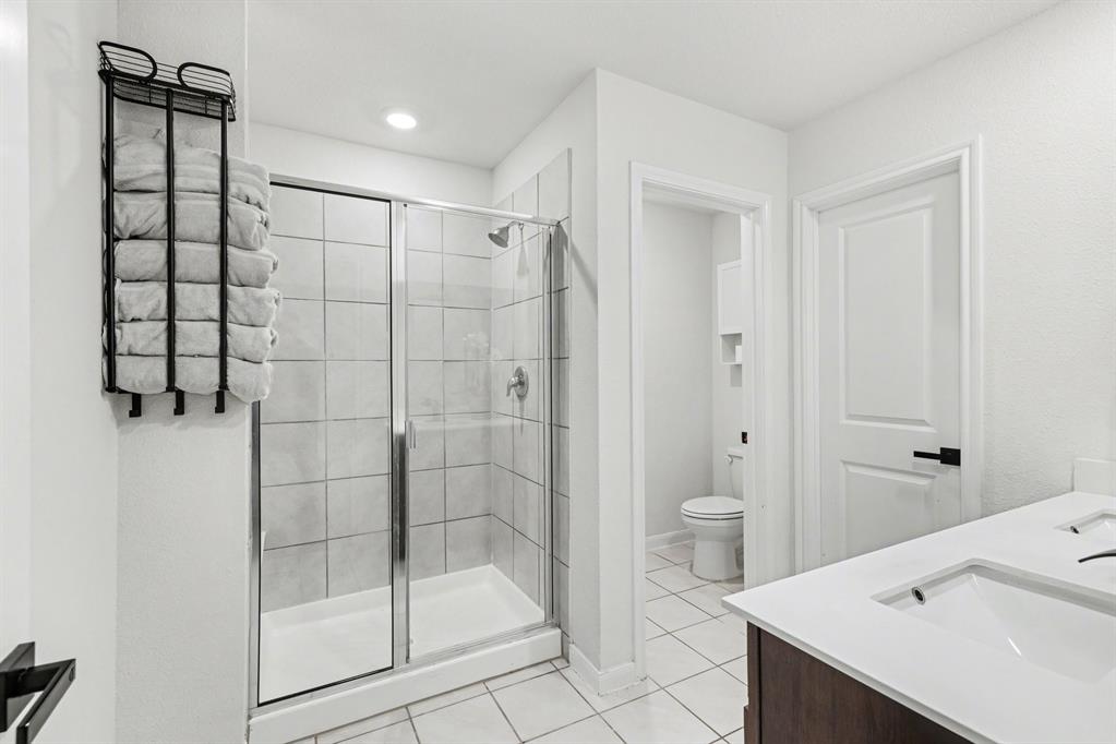 706 Spur Ridge Princeton, TX 75407 - Photo 21 of 36 Full bathroom featuring double vanity, a shower stall, and light tile patterned flooring