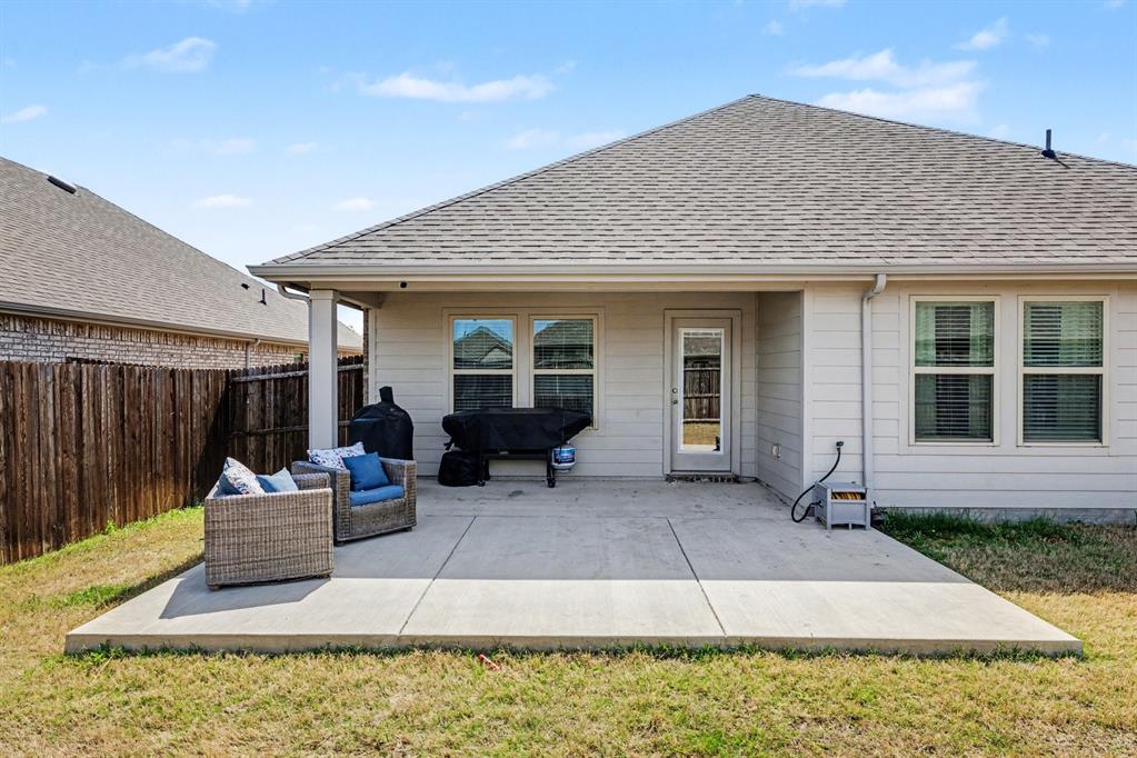 706 Spur Ridge Princeton, TX 75407 - Photo 30 of 36 Back of property with a patio, a fenced backyard, and roof with shingles
