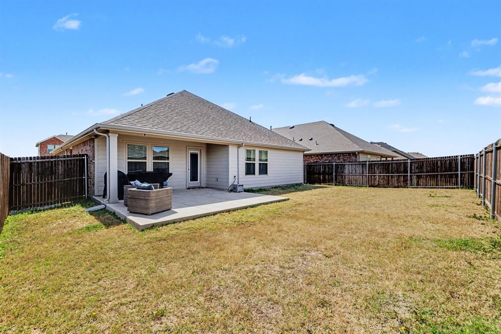706 Spur Ridge Princeton, TX 75407 - Photo 31 of 36 Rear view of house with a patio area, a fenced backyard, and roof with shingles
