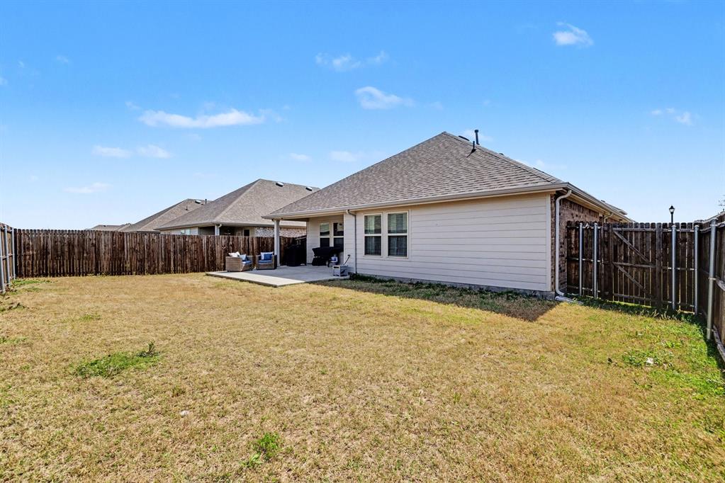 706 Spur Ridge Princeton, TX 75407 - Photo 32 of 36 Back of house with a patio, a fenced backyard, and roof with shingles
