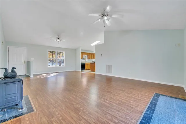 a large kitchen with stainless steel appliances granite countertop a stove top oven a sink dishwasher a dining table and chairs with wooden cabinets