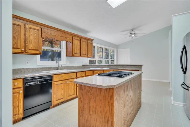 a kitchen with stainless steel appliances granite countertop a sink stove and cabinets
