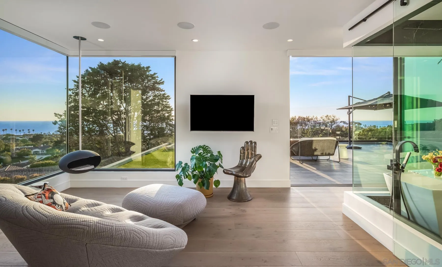 6643 Muirlands Drive La Jolla, CA 92037 - Photo 10 of 16 a living room with furniture a flat screen tv and a large window