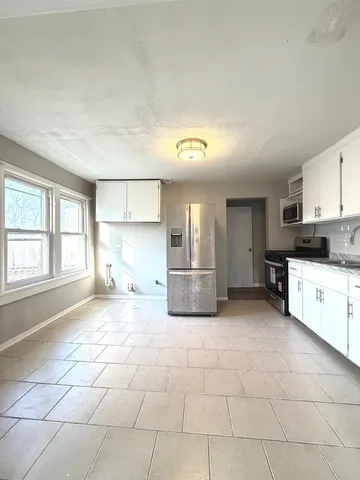 a view of empty room with window and wooden floor