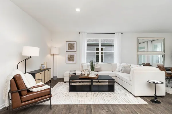 a large white kitchen with stainless steel appliances granite countertop a lot of counter space and wooden floors