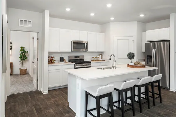 a large kitchen with a table and chairs