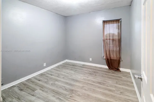 a view of a hallway with wooden floor and closet area