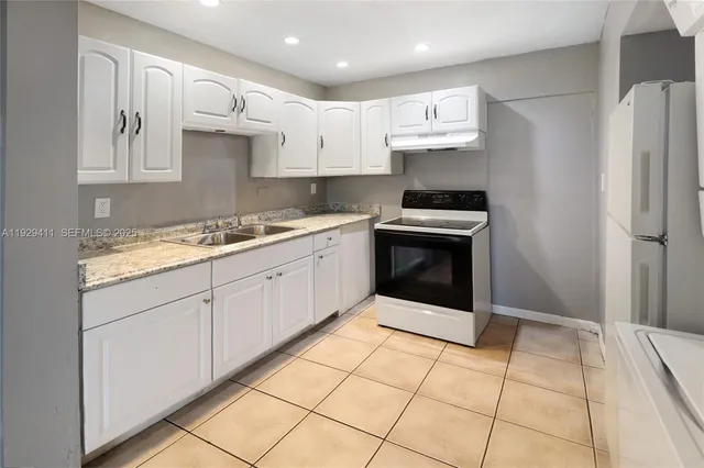 a kitchen with stainless steel appliances granite countertop a stove a sink and a refrigerator