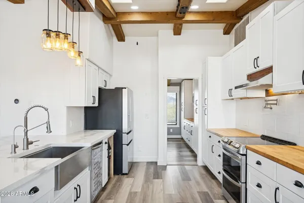a kitchen with stainless steel appliances kitchen island granite countertop a stove and white cabinets