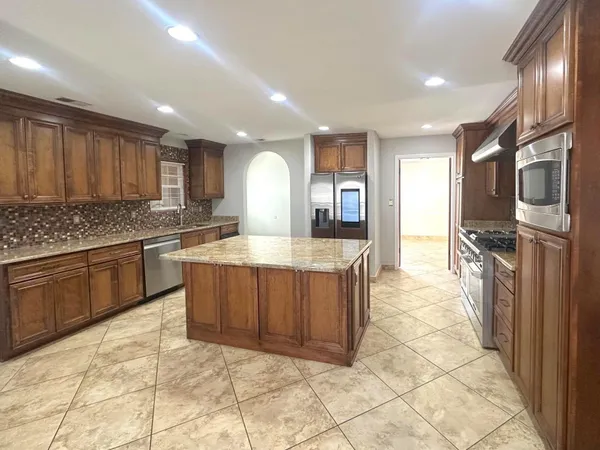 a large kitchen with stainless steel appliances and cabinets
