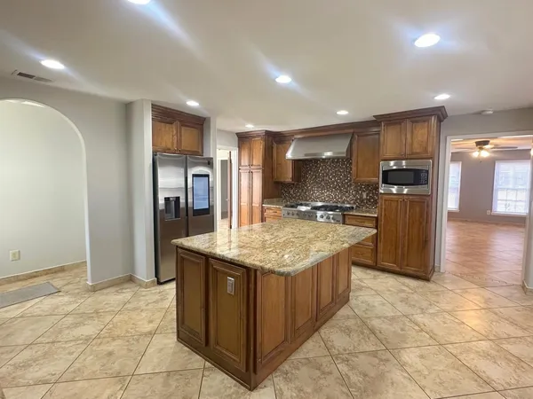 a kitchen with stainless steel appliances granite countertop a sink and a refrigerator