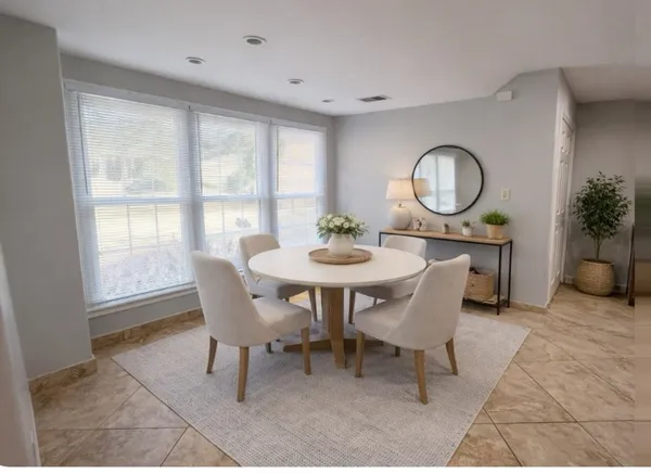 a dining room with furniture and a window