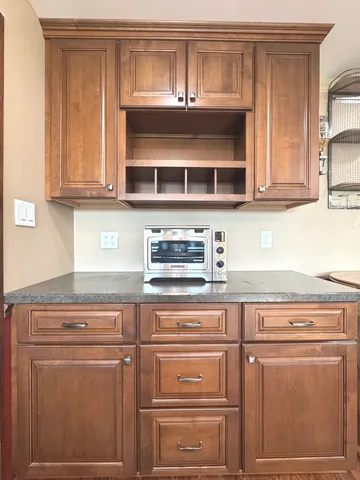 a kitchen with granite countertop white cabinets and stainless steel appliances