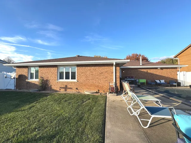 a view of a patio with table and chairs near a yard