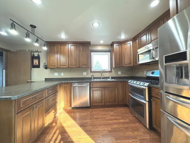a kitchen with stainless steel appliances granite countertop a stove sink and cabinets