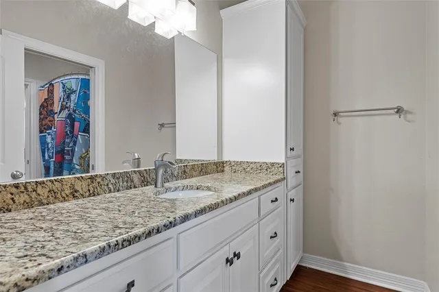 a bathroom with a granite countertop sink and a mirror