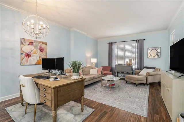 a living room with furniture a flat screen tv and a window