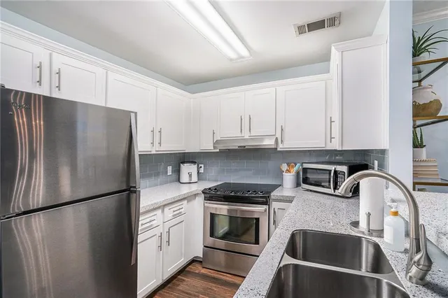 a kitchen with stainless steel appliances a refrigerator sink and cabinets