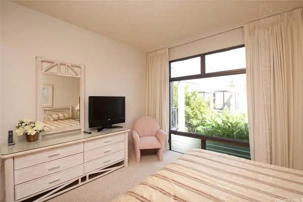 a bedroom with a bed and a flat screen tv