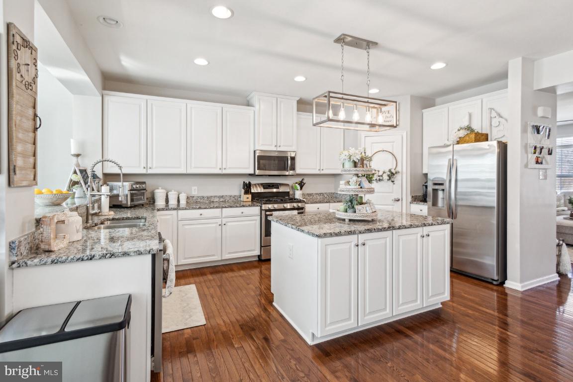 16 Grace Drive Marlton, NJ 08053 - Photo 8 of 24 a kitchen with stainless steel appliances granite countertop a stove a sink dishwasher a refrigerator and white cabinets with wooden floor