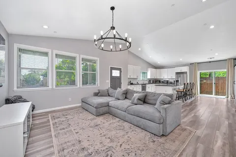 a living room with furniture kitchen and a large window