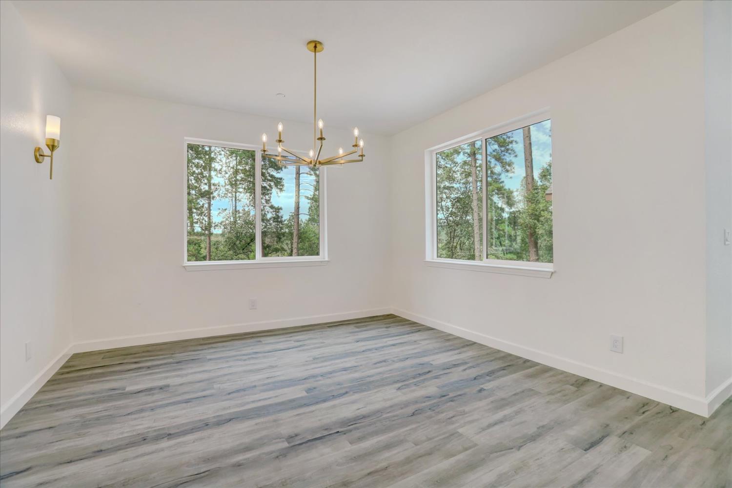 10279 Evergreen Ranch Court Grass Valley, CA 95949 - Photo 36 of 79 an empty room with wooden floor windows and outdoor view