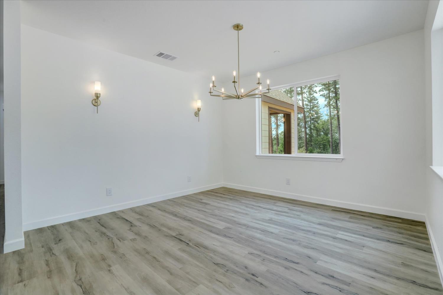 10279 Evergreen Ranch Court Grass Valley, CA 95949 - Photo 38 of 79 an empty room with wooden floor and windows