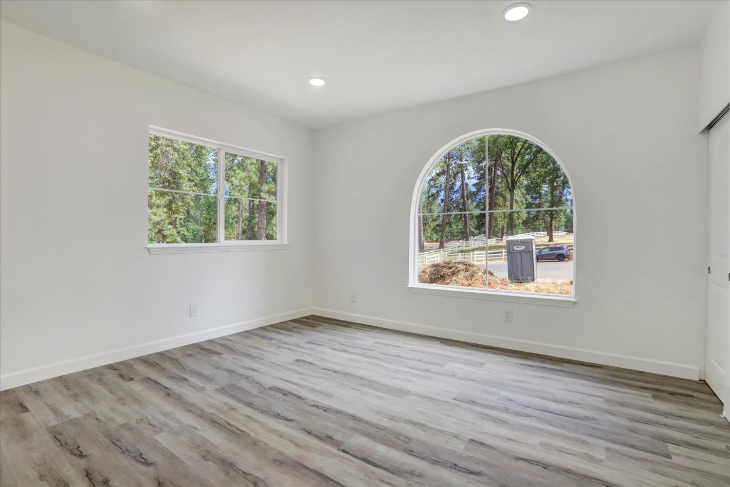 10279 Evergreen Ranch Court Grass Valley, CA 95949 - Photo 49 of 79 an empty room with wooden floor windows and exposed bricks