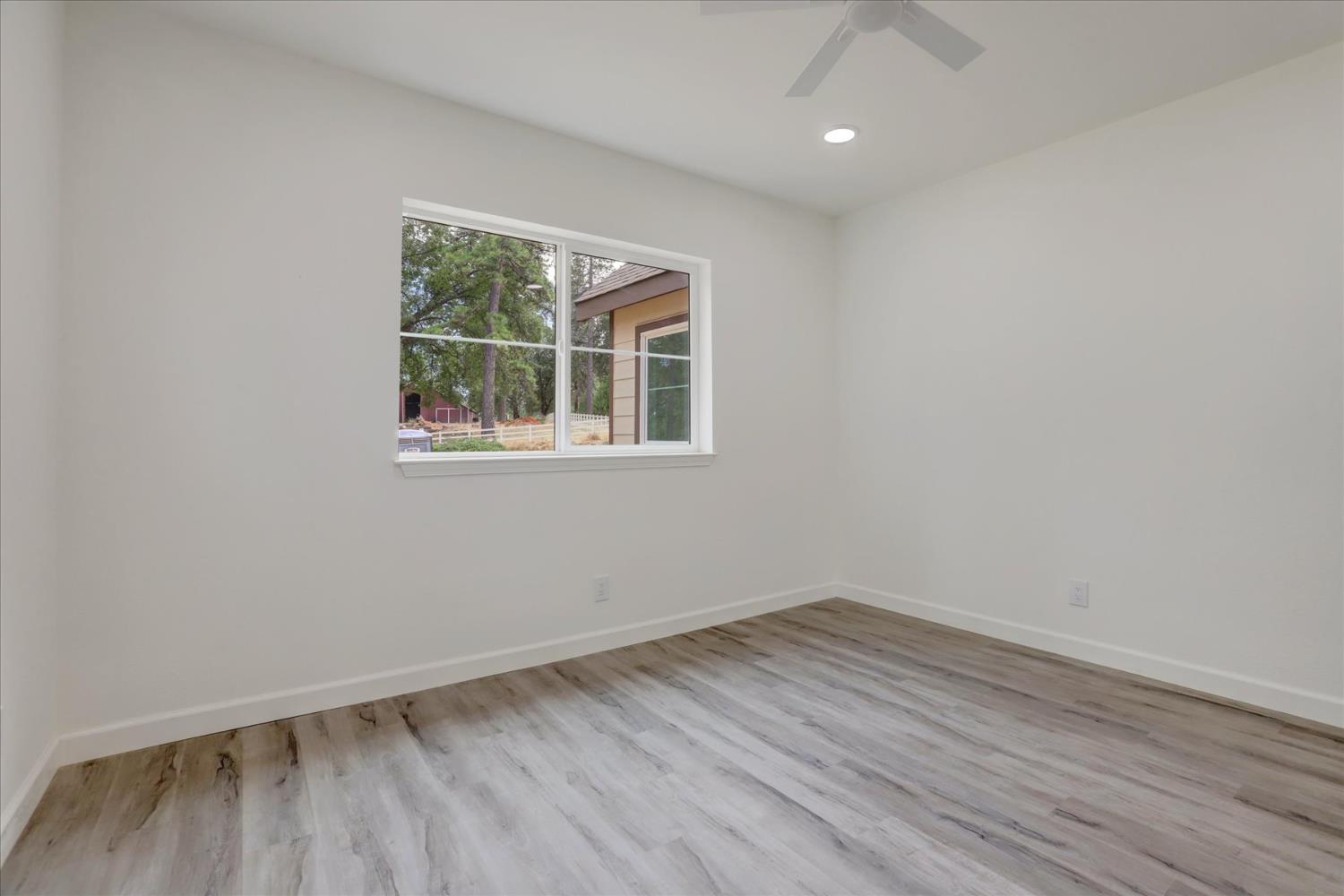 10279 Evergreen Ranch Court Grass Valley, CA 95949 - Photo 56 of 79 an empty room with wooden floor and windows