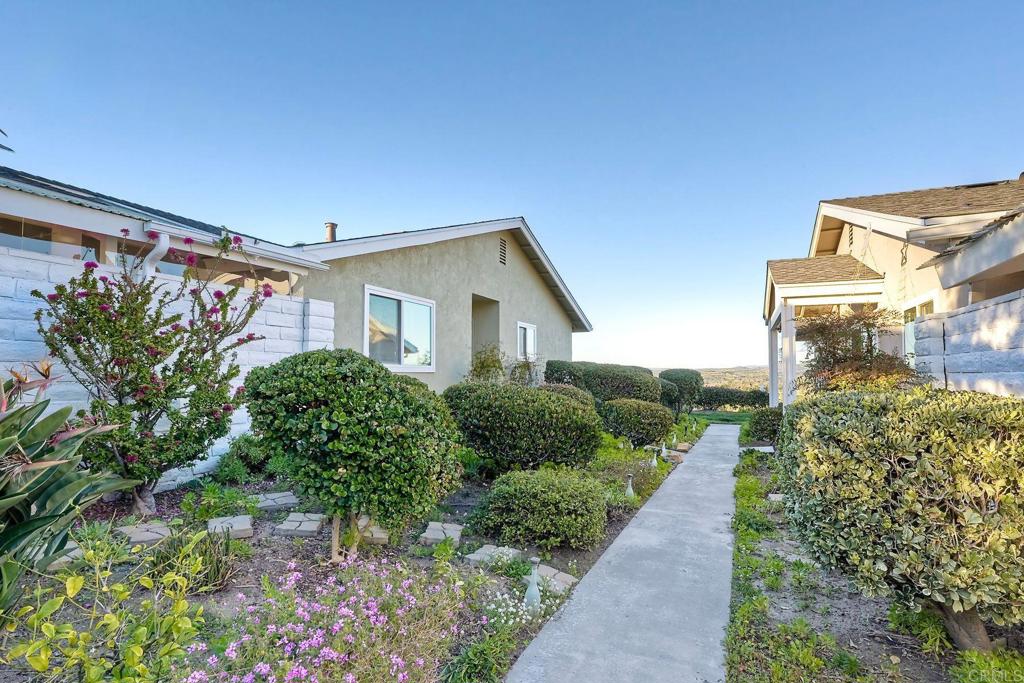 a view of a house with a yard and pathway