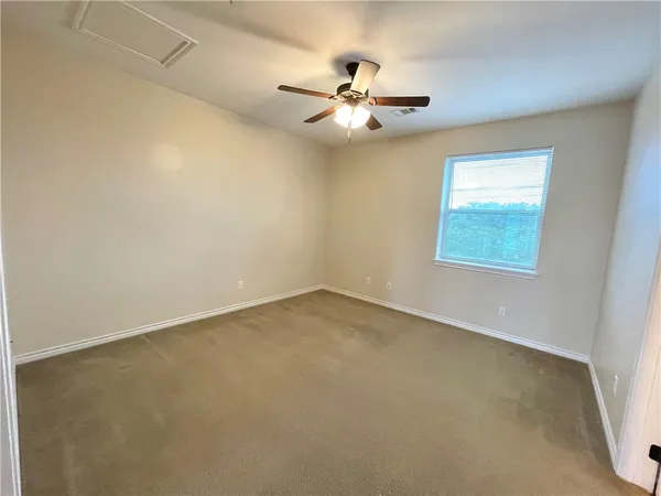 an empty room with a window and a fan
