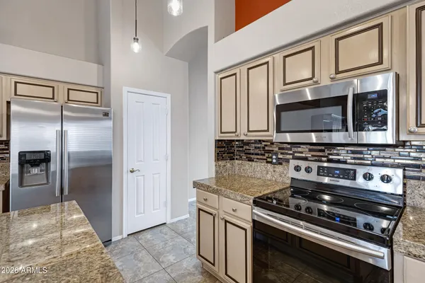 a kitchen with stainless steel appliances granite countertop a stove microwave and refrigerator