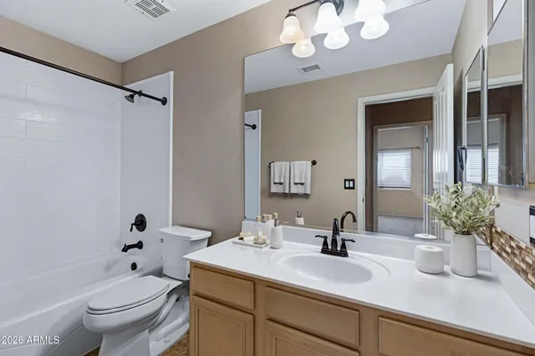 a bathroom with a granite countertop sink a toilet and a mirror
