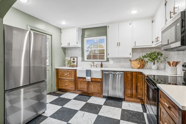 a kitchen with stainless steel appliances granite countertop a refrigerator and a stove top oven