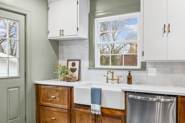 a kitchen with a window a sink and cabinets
