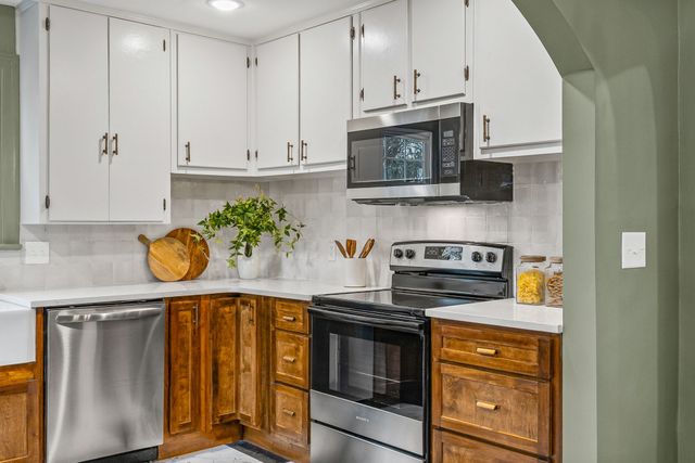 a kitchen with stainless steel appliances granite countertop a stove a microwave and cabinets