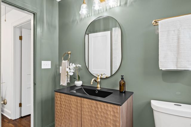 a bathroom with a toilet a sink and a mirror