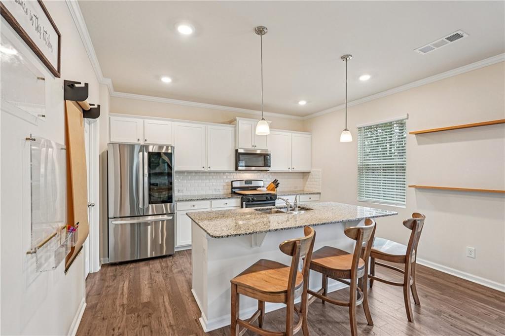88 Cool Creek Court Dallas, GA 30132 - Photo 14 of 41 a kitchen with granite countertop a table chairs stainless steel appliances and wooden floor