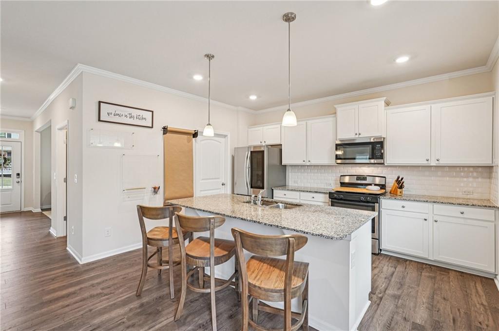 88 Cool Creek Court Dallas, GA 30132 - Photo 15 of 41 a kitchen with stainless steel appliances a stove a sink a refrigerator white cabinets and wooden floor