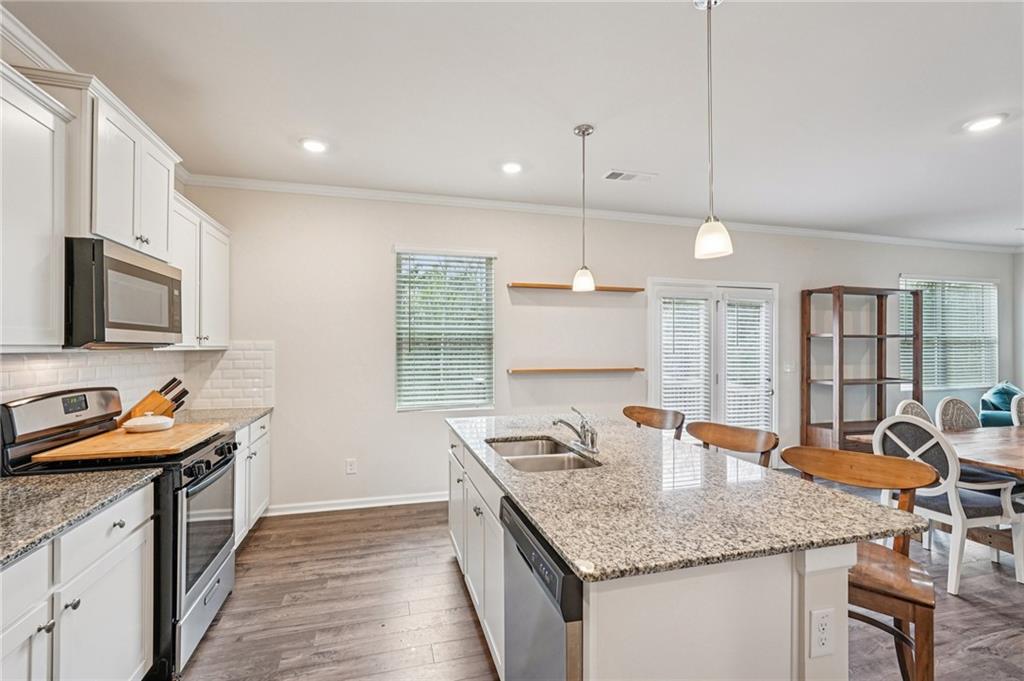 88 Cool Creek Court Dallas, GA 30132 - Photo 19 of 41 a kitchen with stainless steel appliances granite countertop a sink a stove and a wooden floors