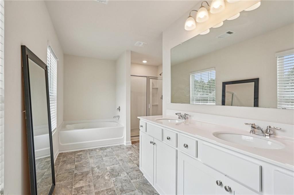 88 Cool Creek Court Dallas, GA 30132 - Photo 25 of 41 a bathroom with a tub a sink double vanity and a mirror