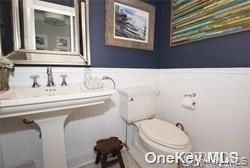 1051 Oceanfront, Unit 7 Long Beach, NY 11561 - Photo 12 of 15 a bathroom with a toilet sink and mirror