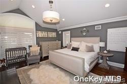 1051 Oceanfront, Unit 7 Long Beach, NY 11561 - Photo 13 of 15 a bedroom with a bed and a chandelier