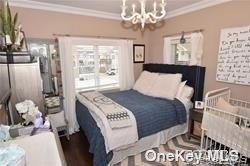 1051 Oceanfront, Unit 7 Long Beach, NY 11561 - Photo 15 of 15 a bedroom with a bed and a chandelier