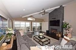 1051 Oceanfront, Unit 7 Long Beach, NY 11561 - Photo 5 of 15 a living room with furniture potted plant a fireplace and a large window
